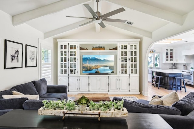 living room with vaulted ceiling with beams, light hardwood / wood-style floors, and ceiling fan