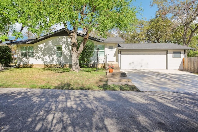 ranch-style house featuring a front yard and a garage