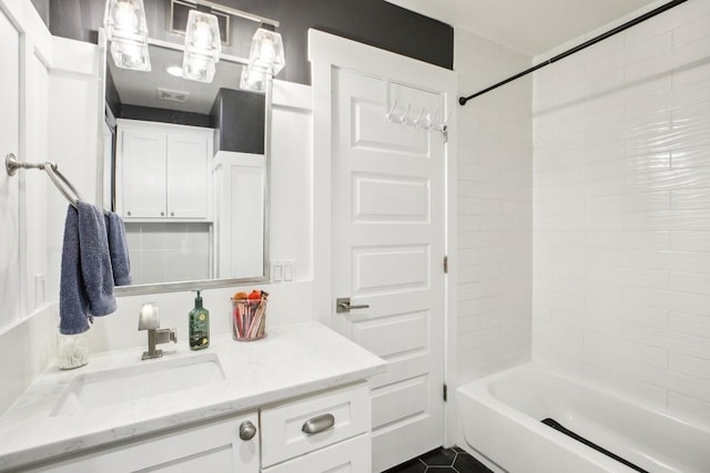 bathroom featuring tile patterned flooring, vanity, and bathing tub / shower combination