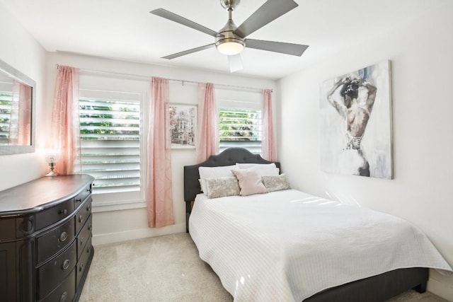 bedroom featuring multiple windows, ceiling fan, and light carpet