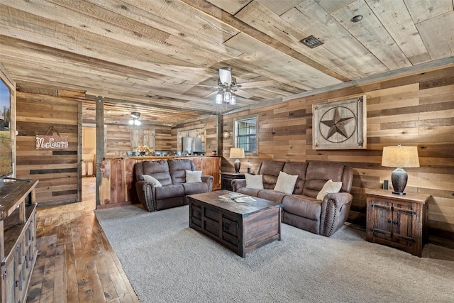 living room with wood walls, ceiling fan, and wooden ceiling