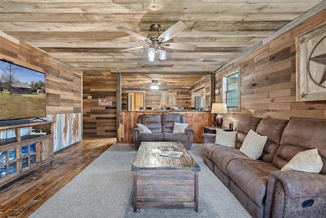 living room with wood walls, hardwood / wood-style floors, ceiling fan, and wood ceiling