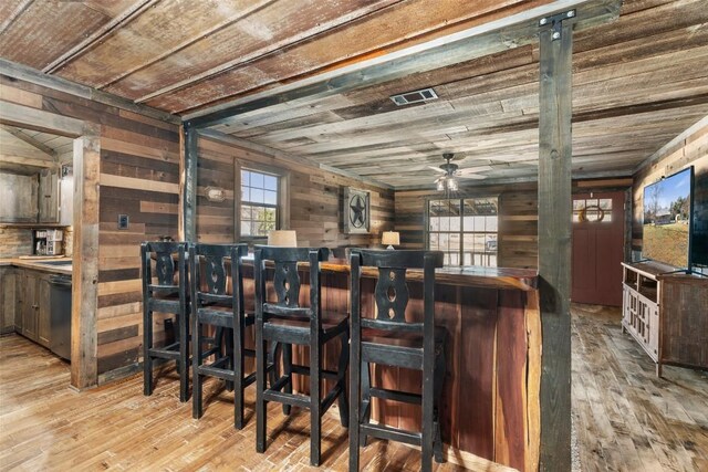 bar featuring wood walls, light hardwood / wood-style flooring, ceiling fan, and wood ceiling