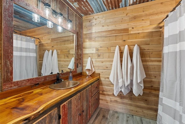 bathroom with vanity, hardwood / wood-style flooring, and wood walls