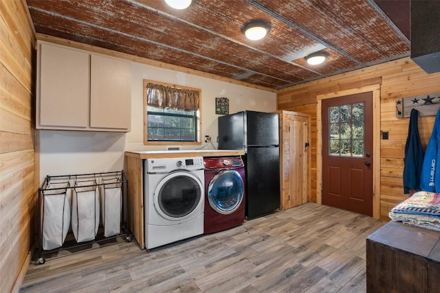 washroom with a healthy amount of sunlight, separate washer and dryer, wooden ceiling, and wood walls