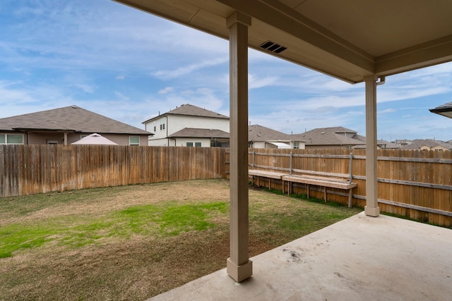 view of yard featuring a residential view, a fenced backyard, and a patio