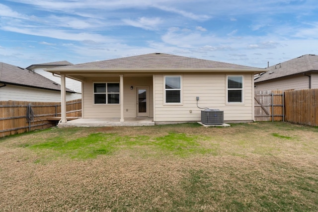 rear view of house featuring a lawn, a patio area, a fenced backyard, and central air condition unit