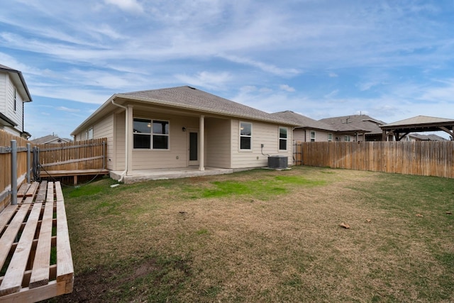 back of house featuring central AC unit, a patio, a fenced backyard, a yard, and a gazebo