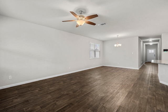 spare room with visible vents, dark wood finished floors, baseboards, and ceiling fan with notable chandelier