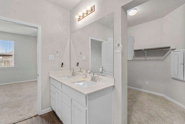 full bath featuring a sink, baseboards, and double vanity