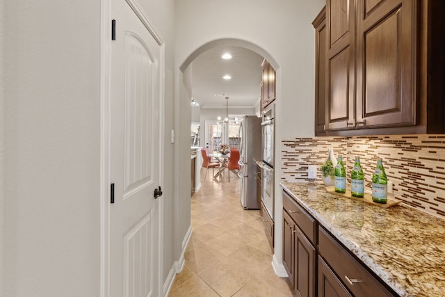 hall featuring a chandelier, light tile patterned floors, and ornamental molding