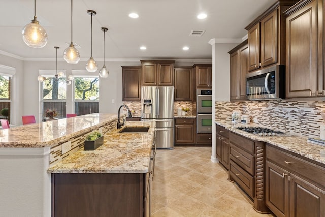 kitchen featuring appliances with stainless steel finishes, hanging light fixtures, a large island, and sink