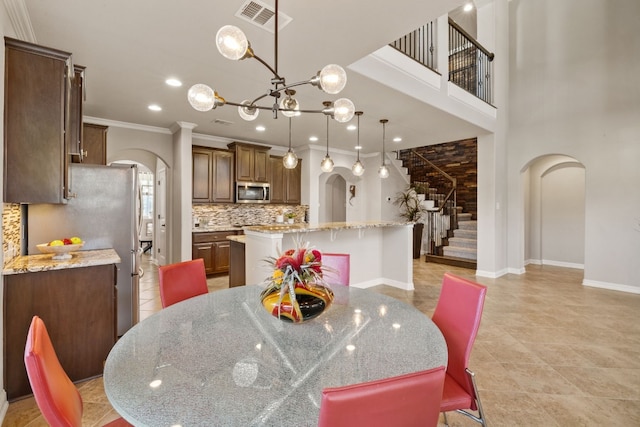 dining room with crown molding and a notable chandelier