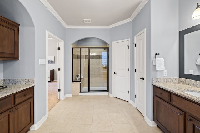 bathroom featuring tile patterned floors, vanity, crown molding, and walk in shower