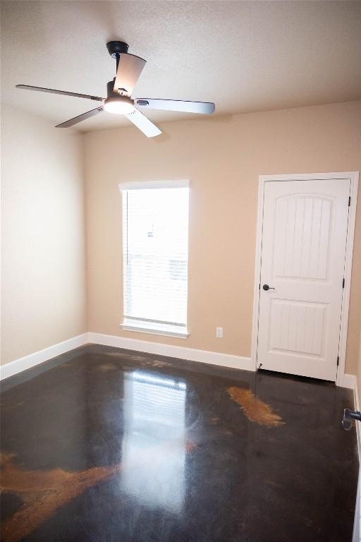 unfurnished room featuring ceiling fan and concrete flooring