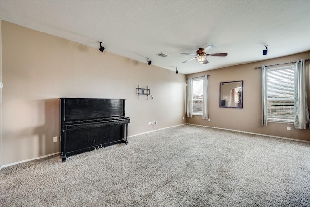 unfurnished living room with a textured ceiling, ceiling fan, and carpet flooring