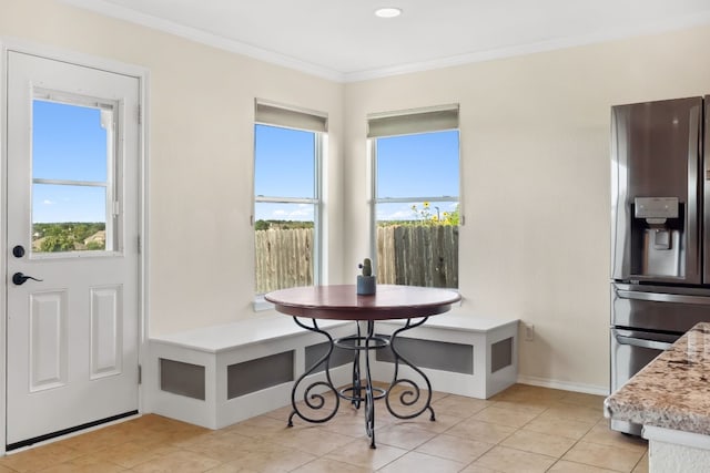 dining area featuring crown molding, breakfast area, and light tile patterned flooring