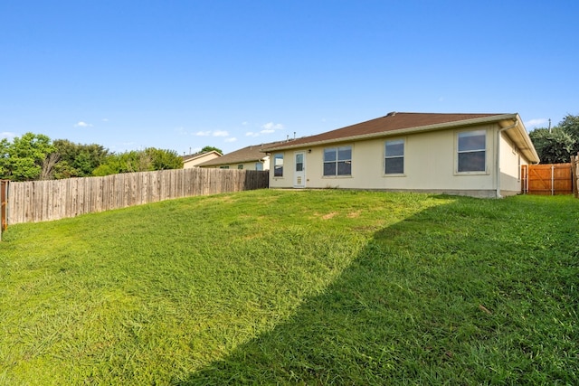 rear view of house featuring a lawn