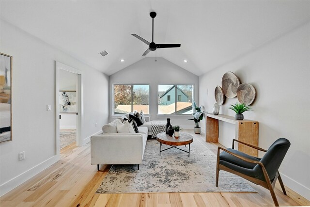 living room featuring vaulted ceiling, light hardwood / wood-style flooring, and ceiling fan