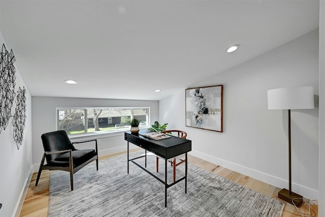 office space featuring vaulted ceiling and light wood-type flooring