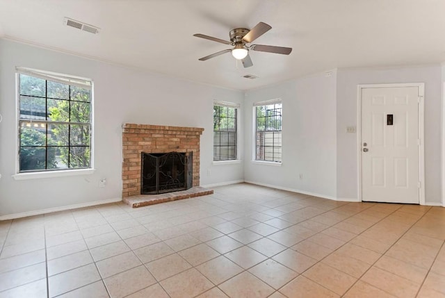 unfurnished living room featuring a fireplace, light tile patterned floors, a wealth of natural light, and ceiling fan