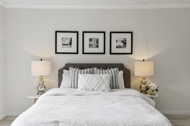 bedroom featuring crown molding and wood-type flooring