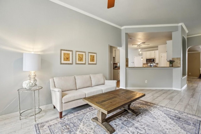 living room featuring crown molding, light hardwood / wood-style floors, and ceiling fan