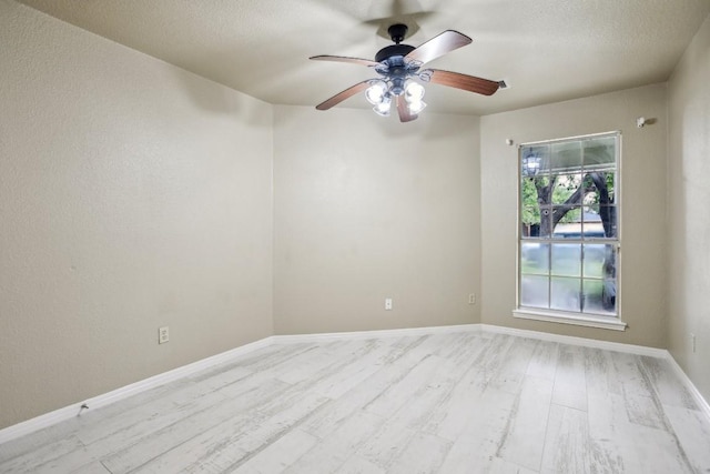 empty room featuring ceiling fan, a textured ceiling, and light wood-type flooring