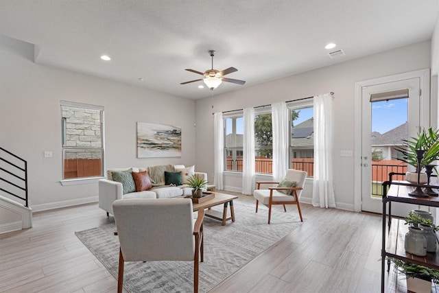 living room with ceiling fan and light hardwood / wood-style floors