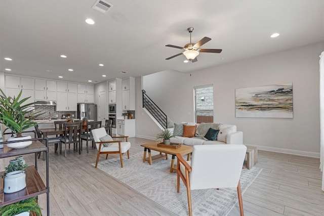 living room featuring ceiling fan and light hardwood / wood-style floors