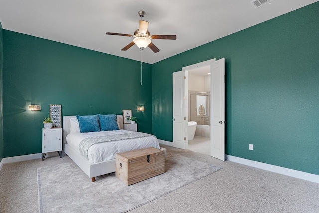 carpeted bedroom with ensuite bathroom and ceiling fan