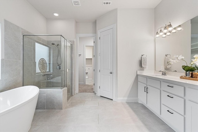 bathroom featuring vanity, tile patterned flooring, and plus walk in shower