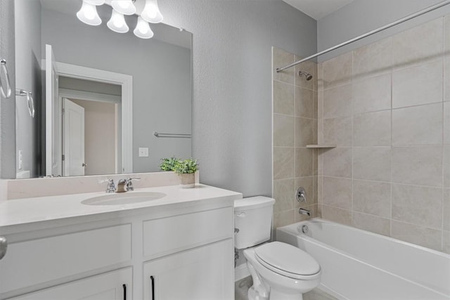 full bathroom featuring tiled shower / bath combo, vanity, and toilet