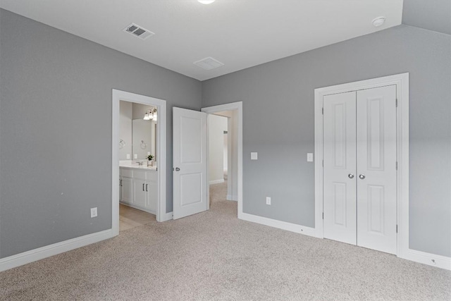 unfurnished bedroom featuring light carpet, connected bathroom, and a closet