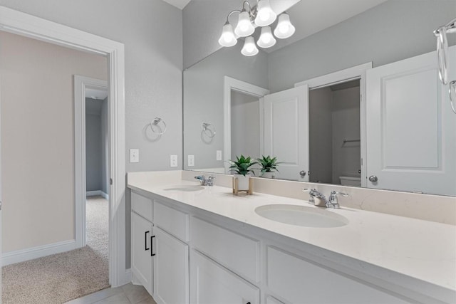 bathroom featuring vanity, an inviting chandelier, and toilet