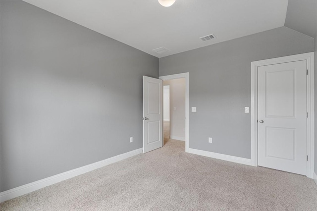 unfurnished bedroom with light carpet and vaulted ceiling