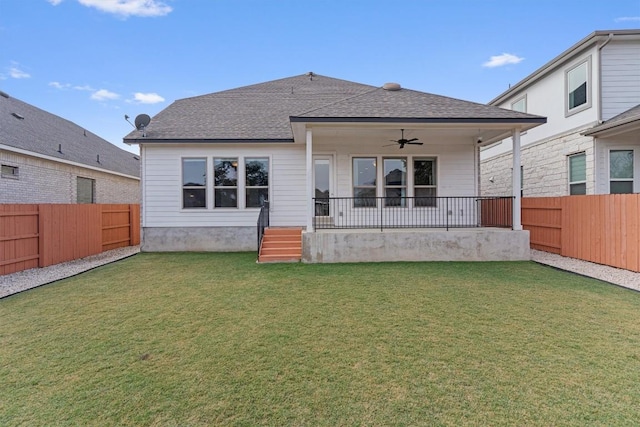 rear view of house featuring ceiling fan and a lawn