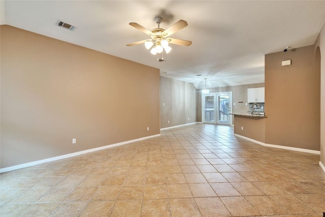 spare room with ceiling fan, french doors, and light tile patterned floors