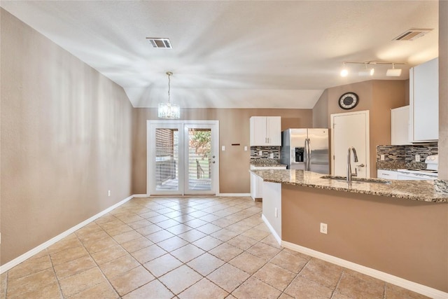 kitchen featuring decorative backsplash, stainless steel refrigerator with ice dispenser, sink, white cabinets, and lofted ceiling