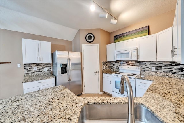 kitchen featuring white appliances, white cabinets, sink, rail lighting, and decorative backsplash