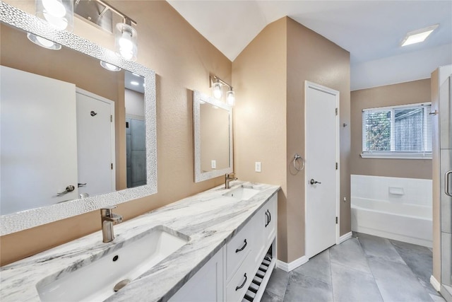 bathroom with vanity, lofted ceiling, and a tub to relax in