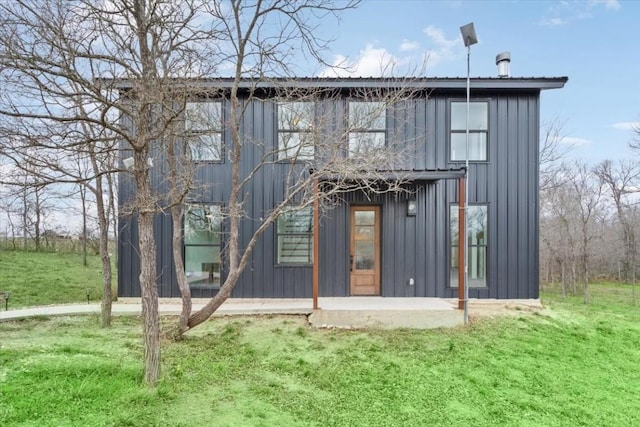 rear view of property featuring a lawn