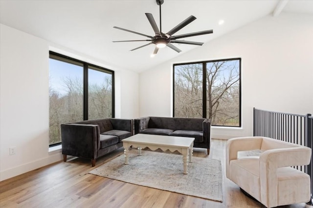 living room with vaulted ceiling with beams, light hardwood / wood-style flooring, and ceiling fan