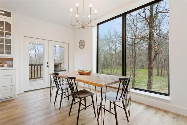 dining room featuring french doors, light hardwood / wood-style floors, and an inviting chandelier