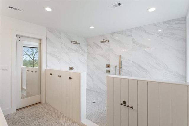 bathroom featuring a tile shower and tile walls