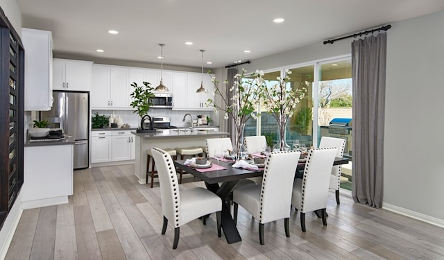 dining area featuring sink and light hardwood / wood-style flooring