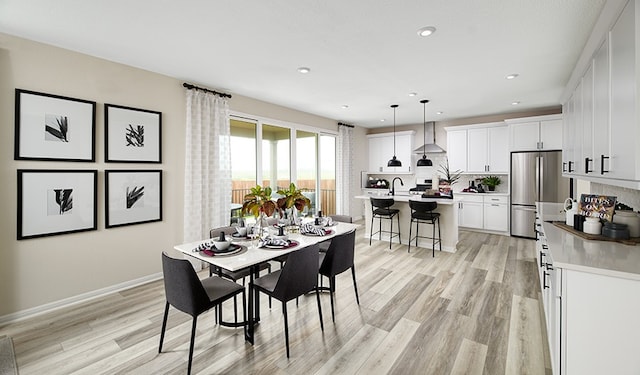 dining room with light hardwood / wood-style floors and sink