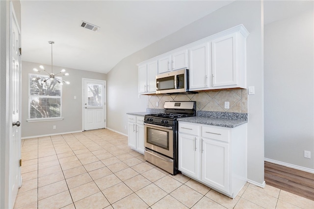 kitchen with decorative backsplash, white cabinetry, and appliances with stainless steel finishes