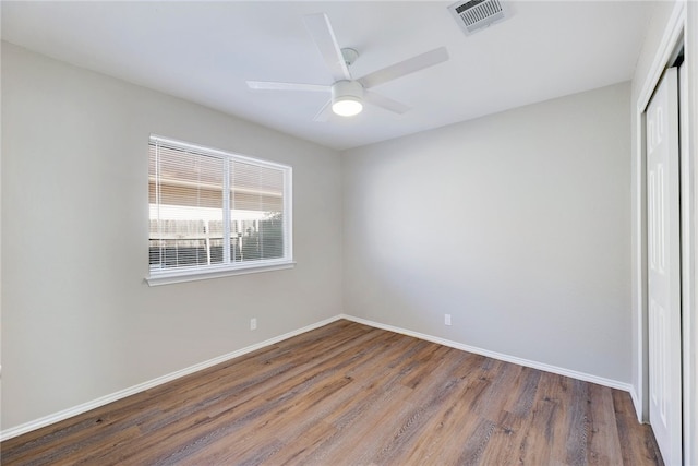 empty room with ceiling fan and dark hardwood / wood-style flooring