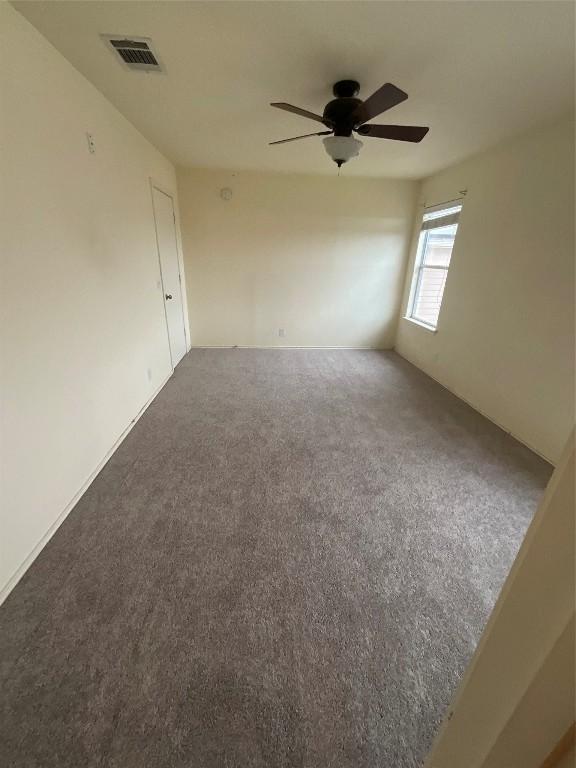 carpeted spare room with ceiling fan